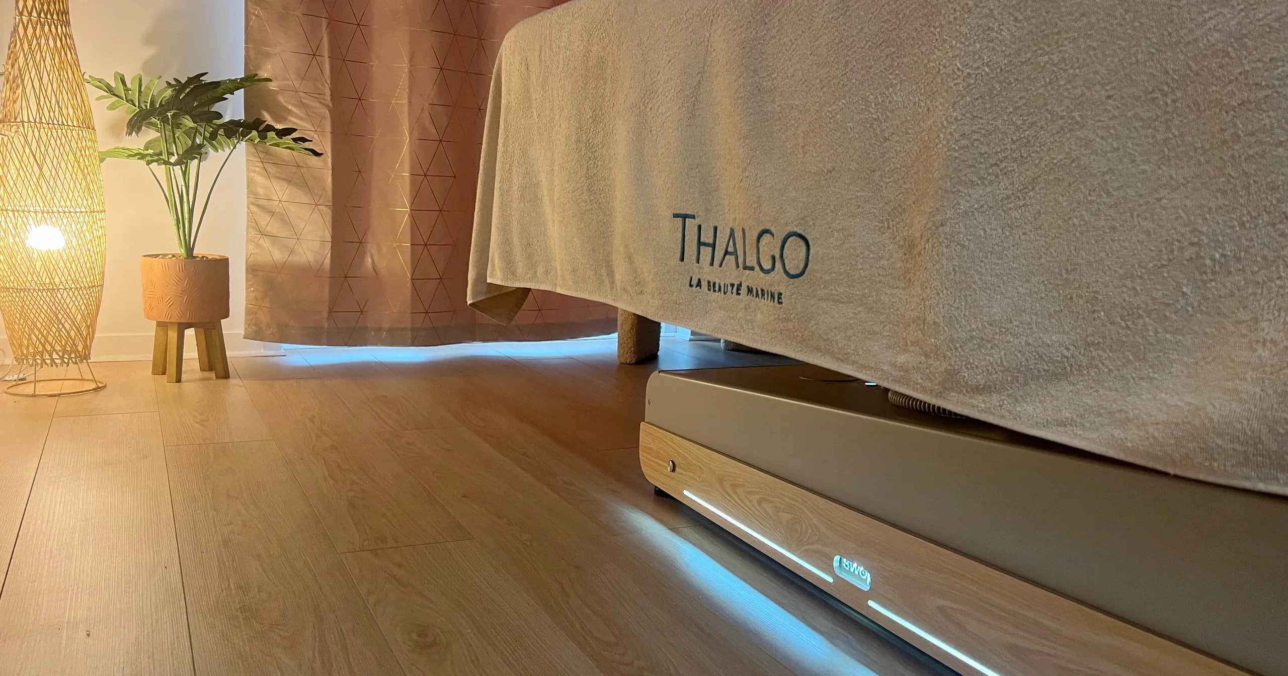 Table de soin recouverte d’une serviette Thalgo, ambiance tamisée de la cabine